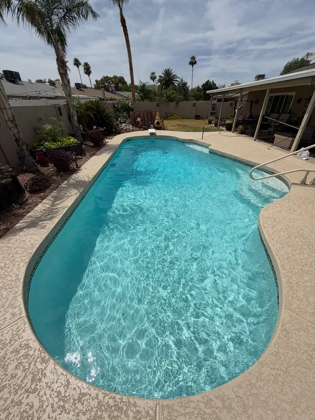 Finished resurfaced pool filled with clear water